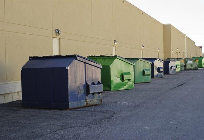 a group of dumpsters lined up along the street ready for use in a large-scale construction project in Advance